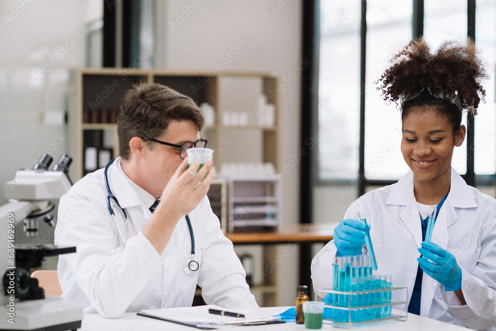 Medical Research Laboratory: Two scientists working, using microscope, analyzing samples, talking, developing biotechnology. Medical Research Laboratory: Two scientists working, using microscope, analyzing samples, talking, developing biotechnology.