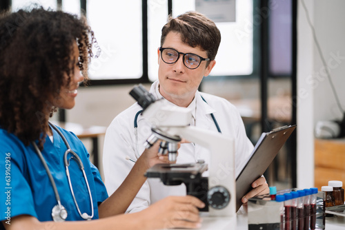 Medical Research Laboratory  Two scientists working  using microscope  analyzing samples  talking  developing biotechnology.