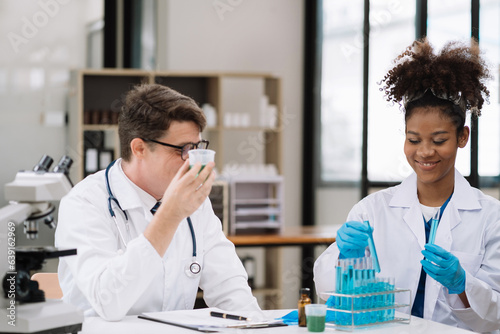 Medical Research Laboratory: Two scientists working, using microscope, analyzing samples, talking, developing biotechnology.