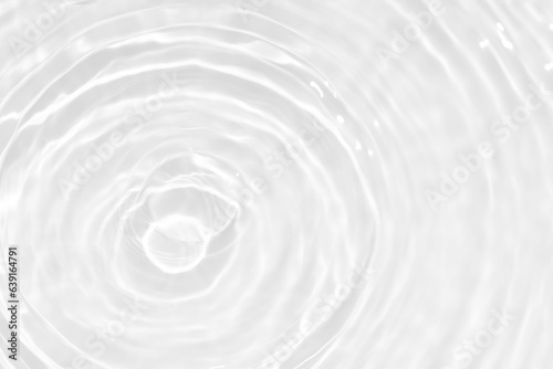 White water with ripples on the surface. Defocus blurred transparent white colored clear calm water surface texture with splashes and bubbles. Water waves with shining pattern texture background.