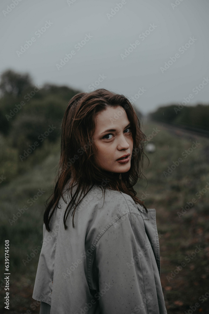 lonely woman on a cloudy day walks in a gray raincoat in nature. The concept of loneliness and existential crisis, rehabilitation. lonely woman on a cloudy day walks in a gray raincoat in nature. The concept of loneliness and existential crisis, rehabilitation.