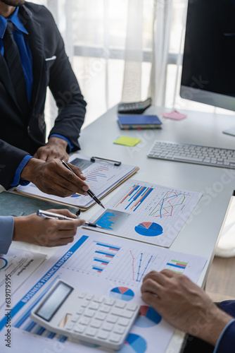 Business team meeting using calculator Working with laptop and charts and analyzing business strategy Financial statistics sitting at the table in the financial office in vertical view