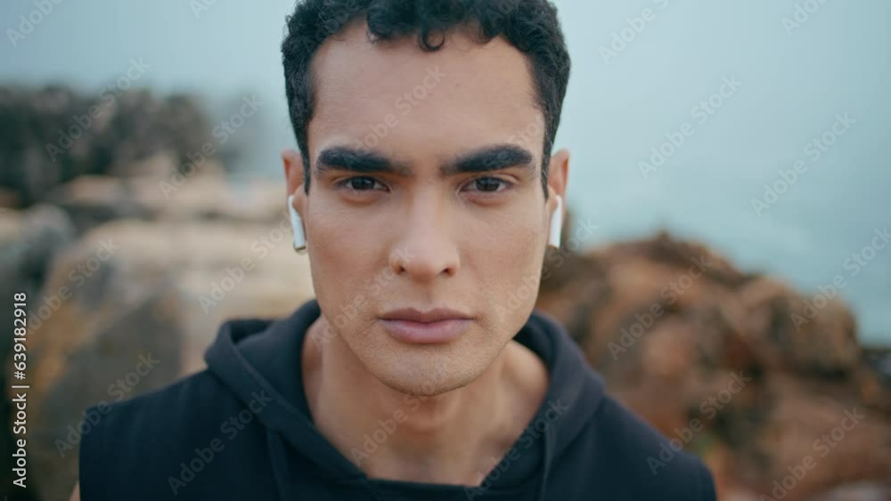 Portrait brunette man posing at ocean cliff view. Zoom in handsome athletic guy Portrait brunette man posing at ocean cliff view. Zoom in handsome athletic guy