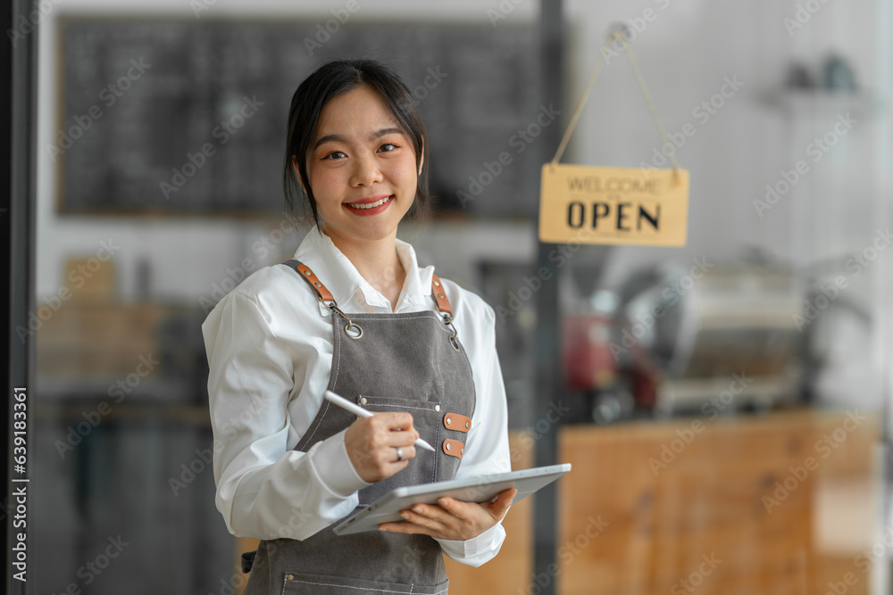 Young successful small business owner standing with tablet in cafe Portrait of an Asian female barista coffee shop owner seller business ideas SME, service, start-up business