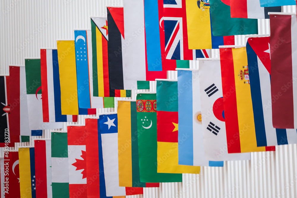 Colorful national flags of various countries hanging in row on street