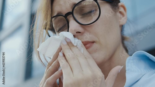 Close-up woman suffering seasonal allergy and rhinitis, sneezing to paper tissue