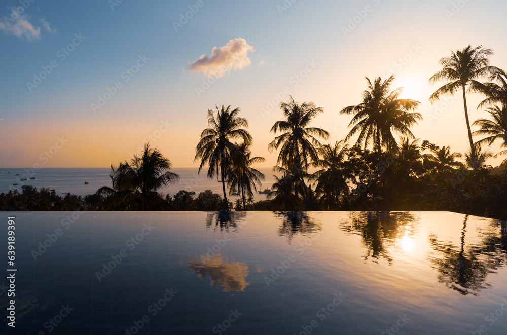 Palms reflections in pool water surface in sunset on tropical Koh Tao Island in Thailand. Exotic resort with beautiful calm seascape