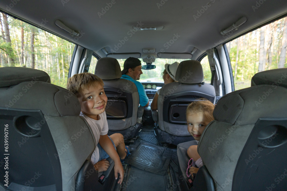 The family goes on a road trip. View from inside the car. A family with children rides on a minivan for an exciting journey. Auto trip family with children. Tourism concept.