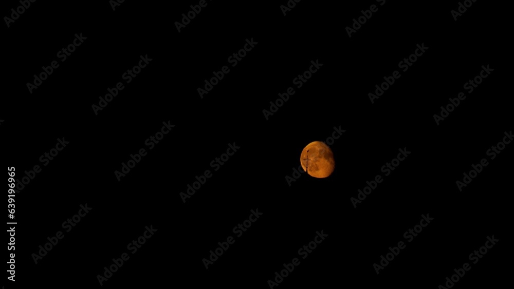 Orange moon in night sky with wind direction arrow in front, time lapse view Orange moon in night sky with wind direction arrow in front, time lapse view