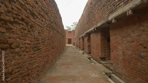 Inside a narrow lane of a ruined monastery with intricate brick masonry walls and rooms excavated at the site of Nalanda Mahavihara an ancient Buddhist Monastic University in Bihar India photo