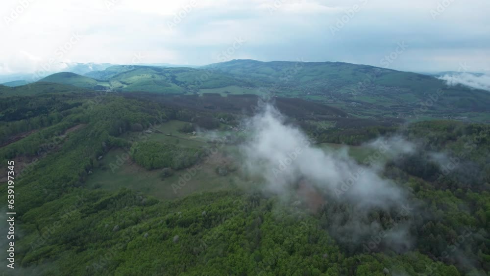 single cloud floating in the air above a green mountain forest area, nature aerial drone shot, vegetated mountains, foggy rainy weather in Banska Bystrica, Tatra Mountains forest, Slovakia. single cloud floating in the air above a green mountain forest area, nature aerial drone shot, vegetated mountains, foggy rainy weather in Banska Bystrica, Tatra Mountains forest, Slovakia.