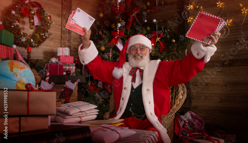 Obraz na plátne Santa Claus rejoicing with letters and mail in his post office indoors Log Cabin