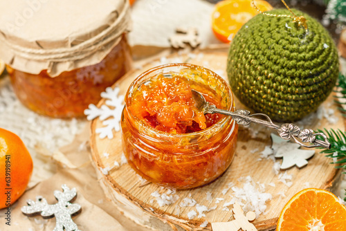 Orange marmalade or orange jam in glass jars. Sweet confiture with festive Christmas decor photo