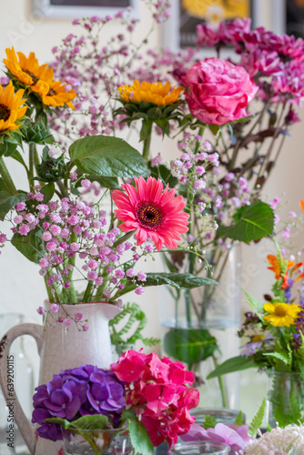 Schöne bunte Blumensträuße in gelb und rosa in Vasen dekorieren ein gemütliches Zuhause