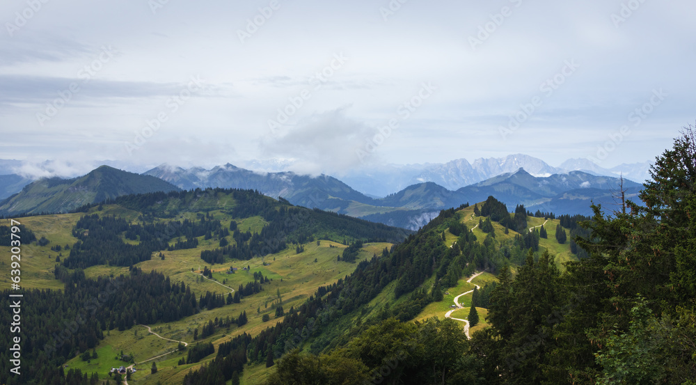 Meadow hill in Alps mountain valley with fog. Austria landscape background