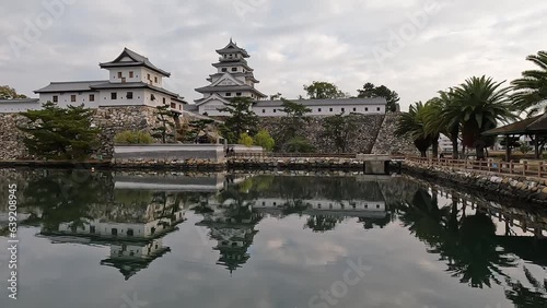 View over the reflectiong imabari castle. Imabari Castle and its steep stone. Amazing reflection in the moat, evening light  Imabari city, Ehime prefecture, Japan photo
