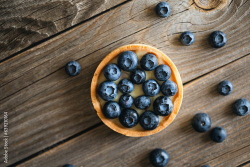 Blueberry tart on a wooden background, top view, copy space.