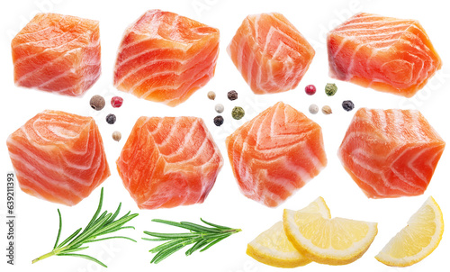 Fresh salmon cubes or salmon pieces with spices and lemon slices on white background. File contains clipping path.