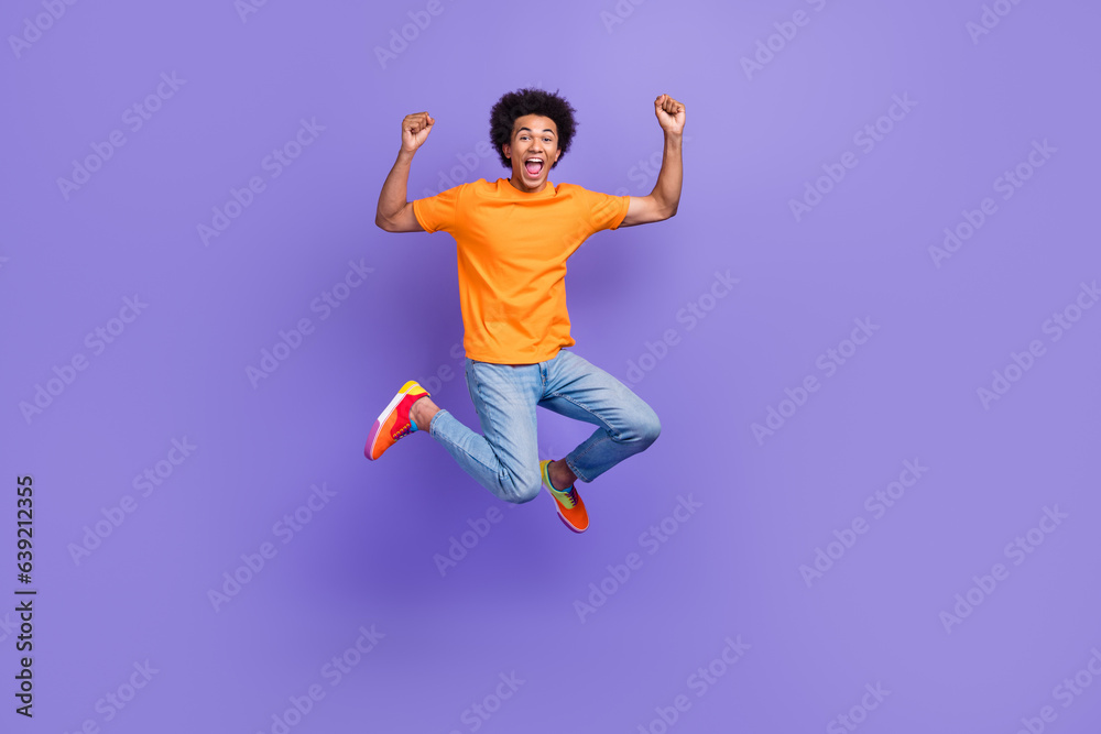 Full body cadre of careless jumping tourist guy summertime big sale abroad travel fists up holidays isolated on purple color background