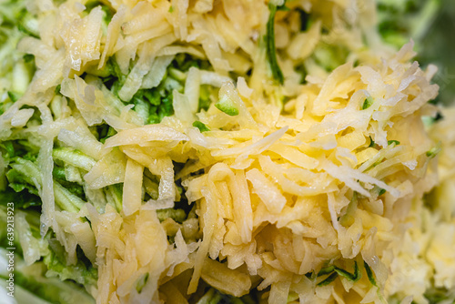 Shredded raw zucchini and potatoes fill the picture. Background of zucchini mucver photo