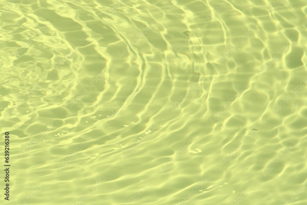 Blue water with ripples on the surface. Defocus blurred transparent blue colored clear calm water surface texture with splashes and bubbles. Water waves with shining pattern texture background.