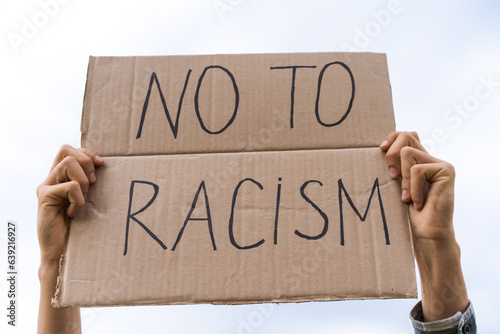 banner in hand no to racism against the sky photo