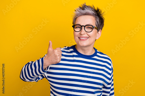 Photo portrait of cheerful pensioner businesswoman thumb up confirmation applicant good choice isolated on yellow color background
