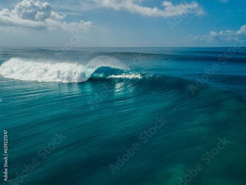 Glassy wave with barrel in blue ocean. Aerial view