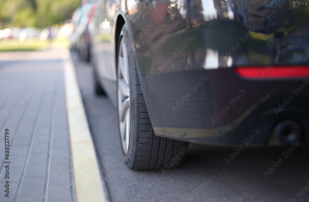 Car standing in front of dividing strip in parking lot closeup. Car parking concept