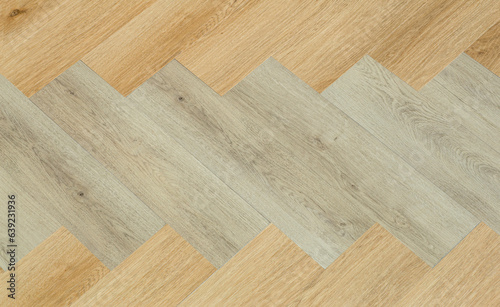 Laminate and parquet with herringbone background. Wooden floor with a chevron pattern in the living room of the designer interior