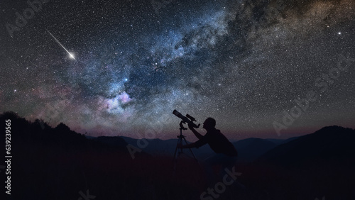 Leinwand Poster Astronomer looking at the starry skies with a telescope.