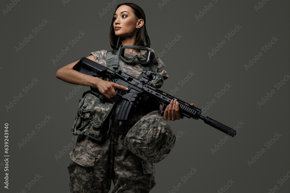 Poster Beautiful female soldier in military uniform stands holding an ...