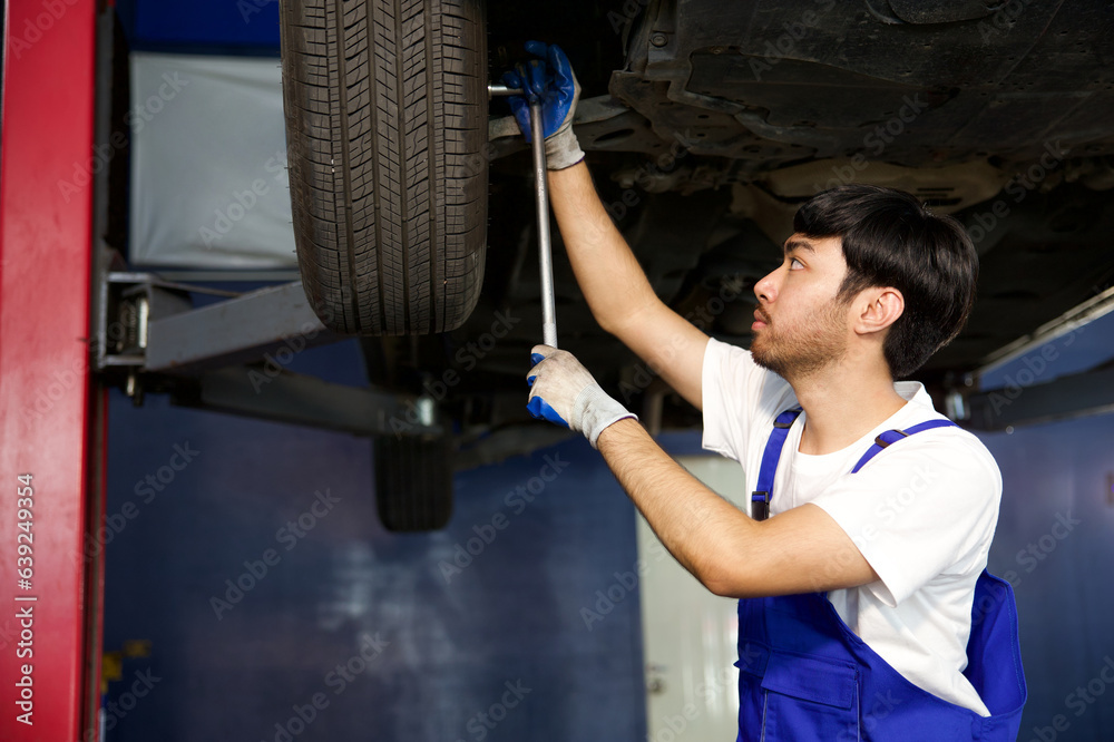mechanic using ratchet wrench and fixing underneath the car mechanic using ratchet wrench and fixing underneath the car