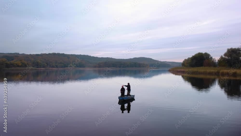 Two men are fishing in a boat on the river. autumn landscape. Aerial view. Two men are fishing in a boat on the river. autumn landscape. Aerial view.