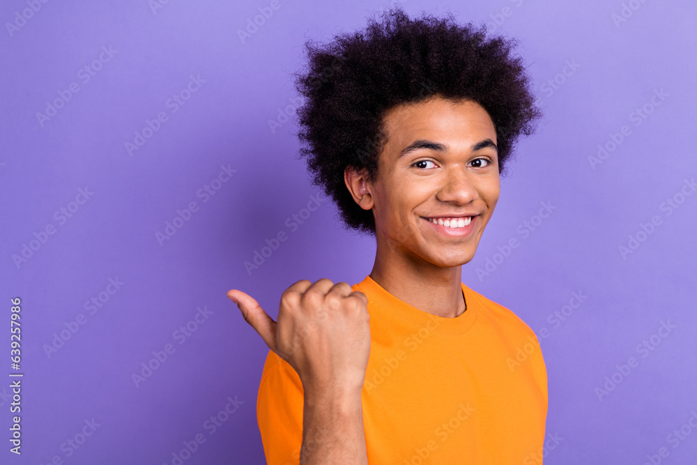 Profile photo of cheerful handsome man beaming smile direct thumb finger empty space isolated on violet color background Profile photo of cheerful handsome man beaming smile direct thumb finger empty space isolated on violet color background