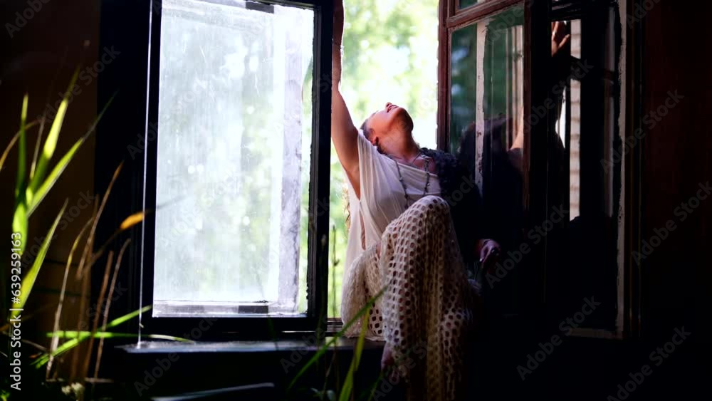 portrait of sexy brunette woman sitting on windowsill in old house, vintage and bohemian style