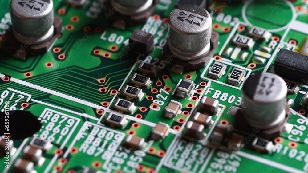Circuit board with components in rotation. Extreme close up of green electronic board, with electronic components.
