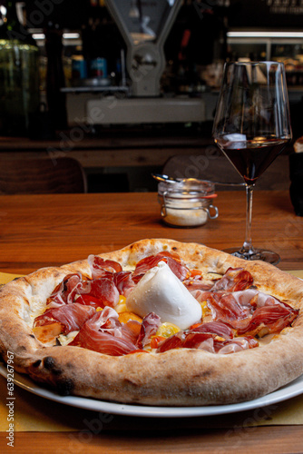 Typical, Italian pizza from the wood-fired oven with real prosciutto from Parma and the Italian cream cheese Burrata, refined with olive oil from organic farming