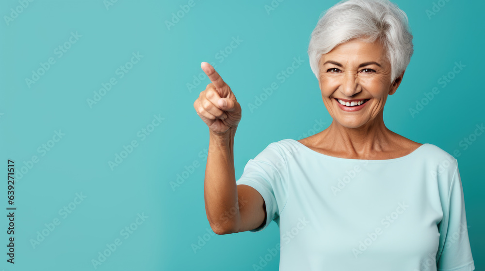 Senior woman wearing white white T-shirt pointing with hand and finger to the side looking at the camera. Senior woman wearing white white T-shirt pointing with hand and finger to the side looking at the camera.