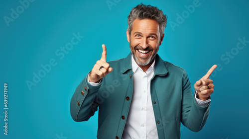 Middle aged man wearing casual clothes pointing with hand and finger to the side looking at the camera.