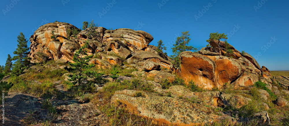 Obraz premium East Kazakhstan. Picturesque view of the ruins of the mountains of the Bayanaul Natural Park, located in the middle of the endless steppes.
