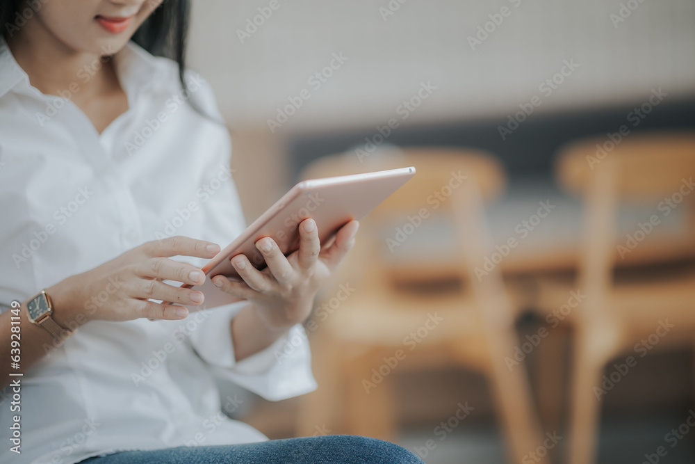 Beautiful smiling Asian woman using touchpad in cafe Beautiful smiling Asian woman using touchpad in cafe