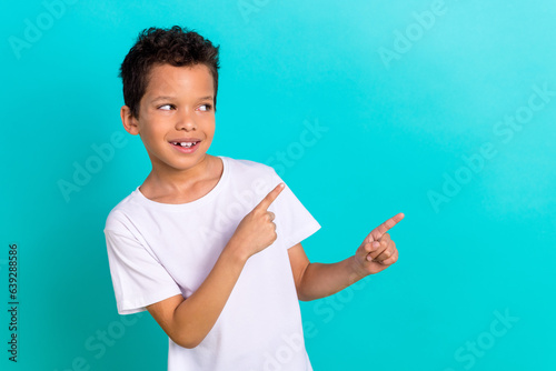 Photo of kind cute boy wear trendy white clothes two arm demonstrate look empty space buy nightwear isolated on cyan color background