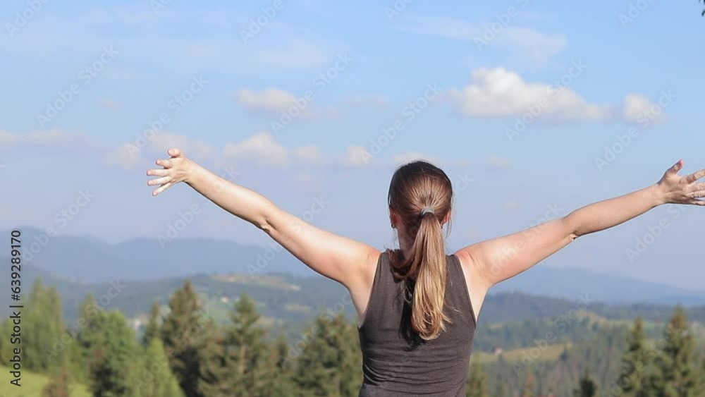 Happy relaxed girl breathes fresh air in the mountains. The concept of relaxation, outdoor living and recreation. A trip to the Carpathian mountains, Ukraine. View from the back of a girl in nature Happy relaxed girl breathes fresh air in the mountains. The concept of relaxation, outdoor living and recreation. A trip to the Carpathian mountains, Ukraine. View from the back of a girl in nature