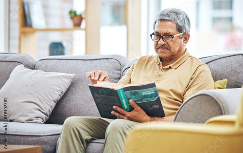 Billede på lærred Home, relax and senior man with a book, retirement and calm with a story in a living room