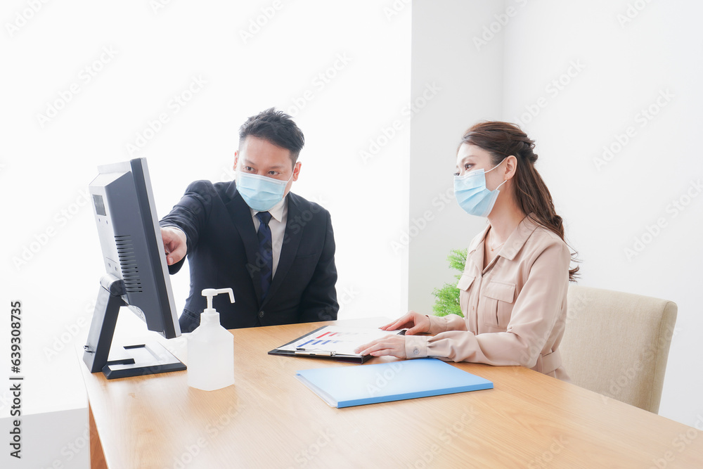 感染症対策をしてオフィスで働くビジネスパーソン 感染症対策をしてオフィスで働くビジネスパーソン