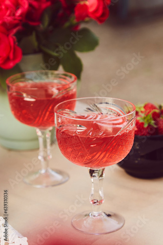 Red sparkling strawberry wine with roses outdoor. Romantic, precious moment concept.