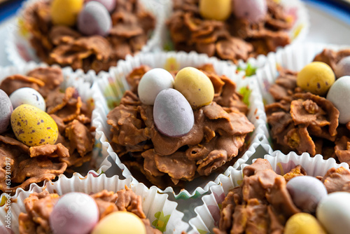 Chocolate pastries shaped like baskets with eggs, packaged in paper, rest on a plate