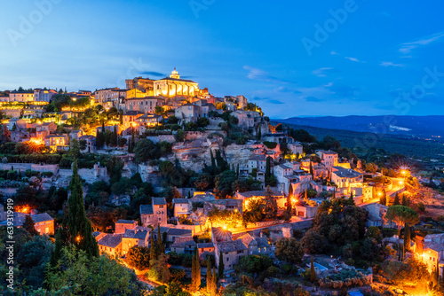 Night view of ancient Provencal town Gordes at dusk with warm lights on the streets. Gordes in Provence; France, Luberon is popular landmark and tourist destination.