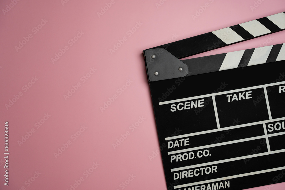 movie clapper on pink table background ; film, cinema and video photography concept